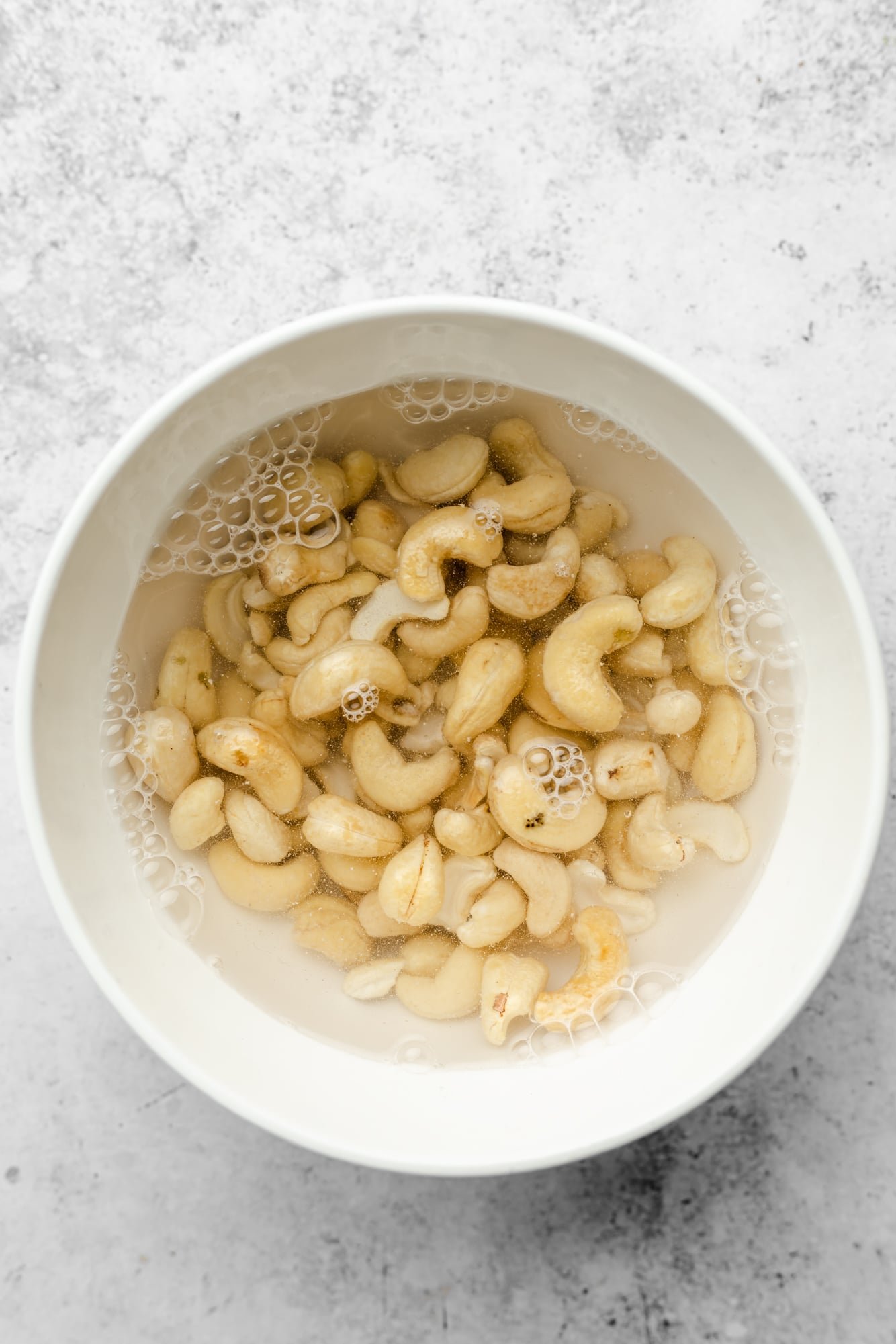 Cashews soaked in water in a bowl.