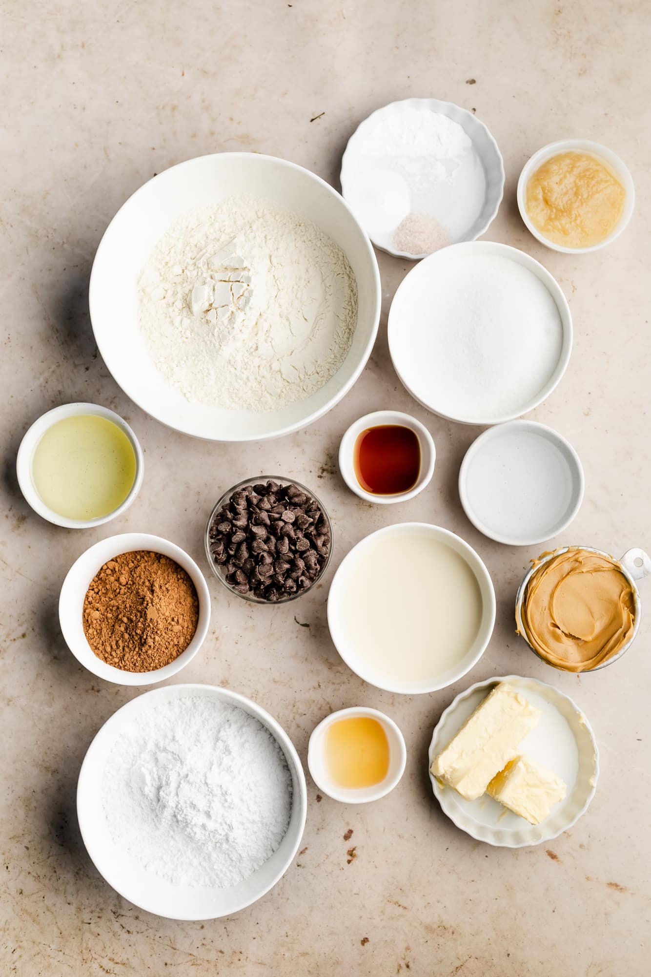 ingredients for chocolate peanut butter cake in individual white bowls.