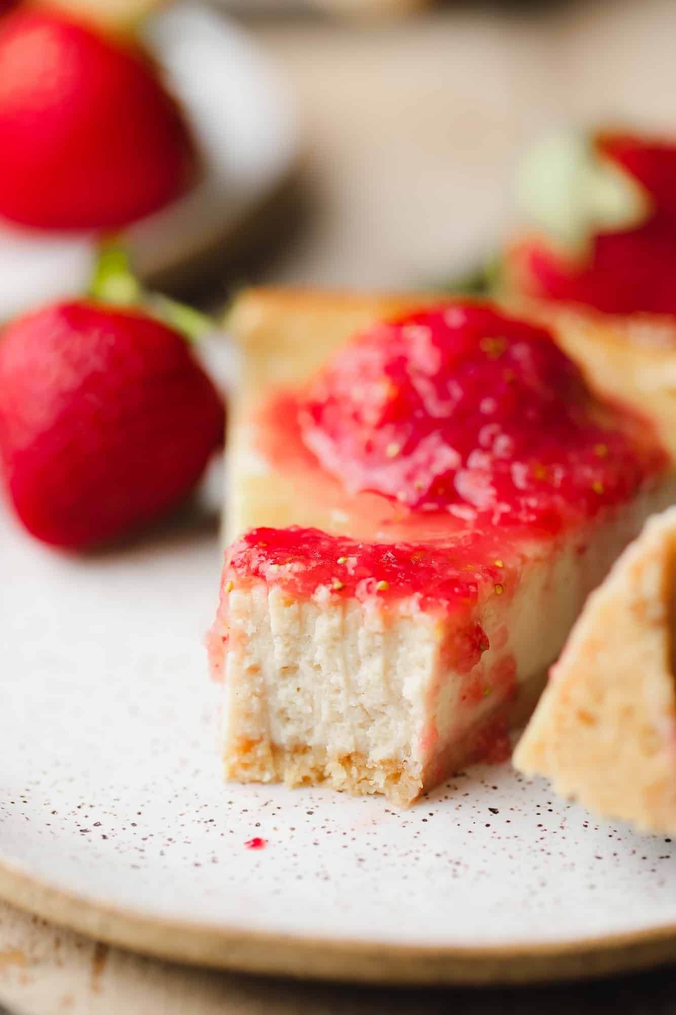 close up on a slice of cashew cheesecake with a bite missing.