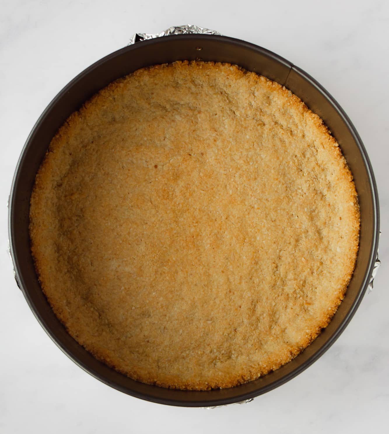 baked almond oat crust in a springform pan.