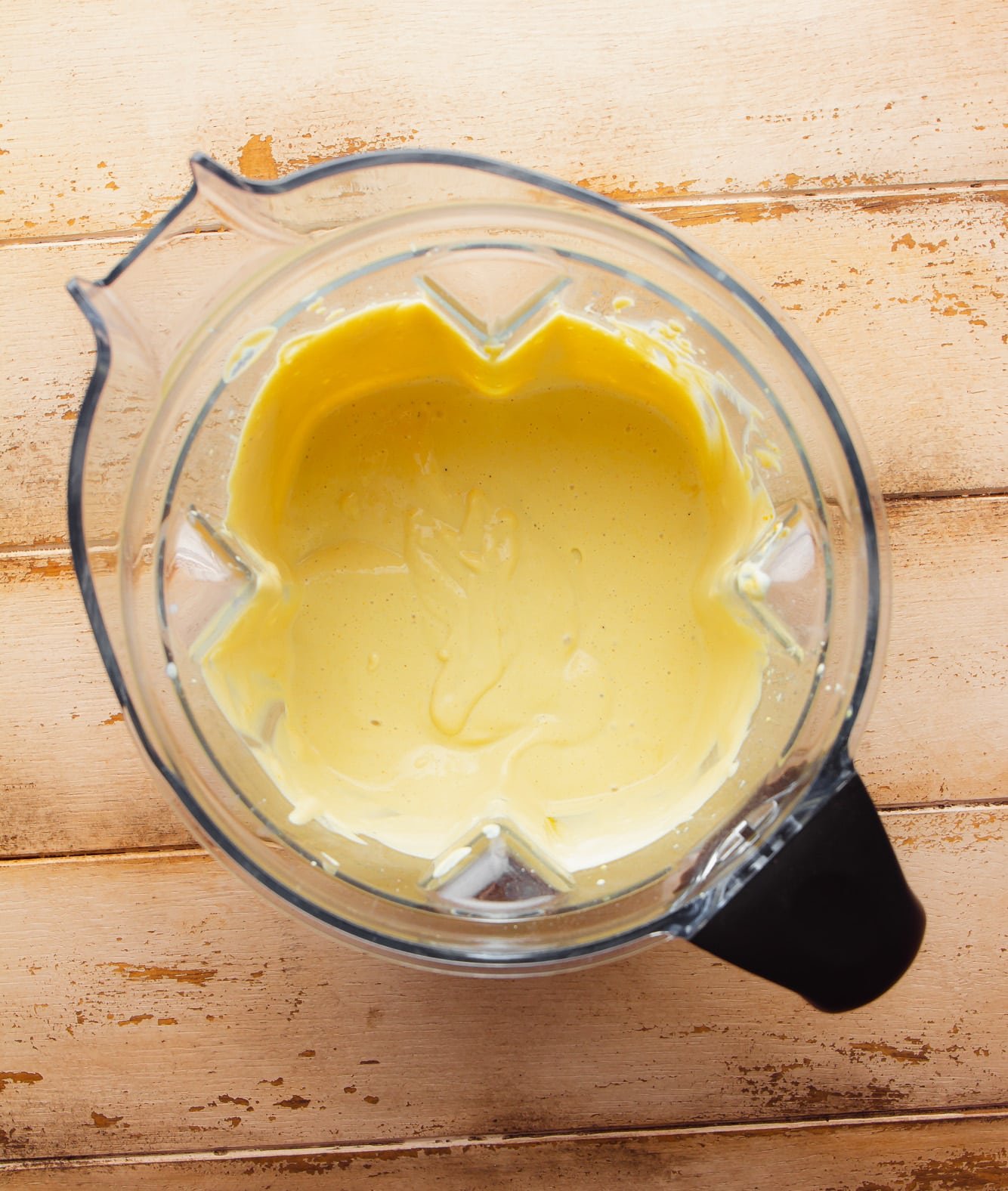 a creamy yellow sauce in a large blender.