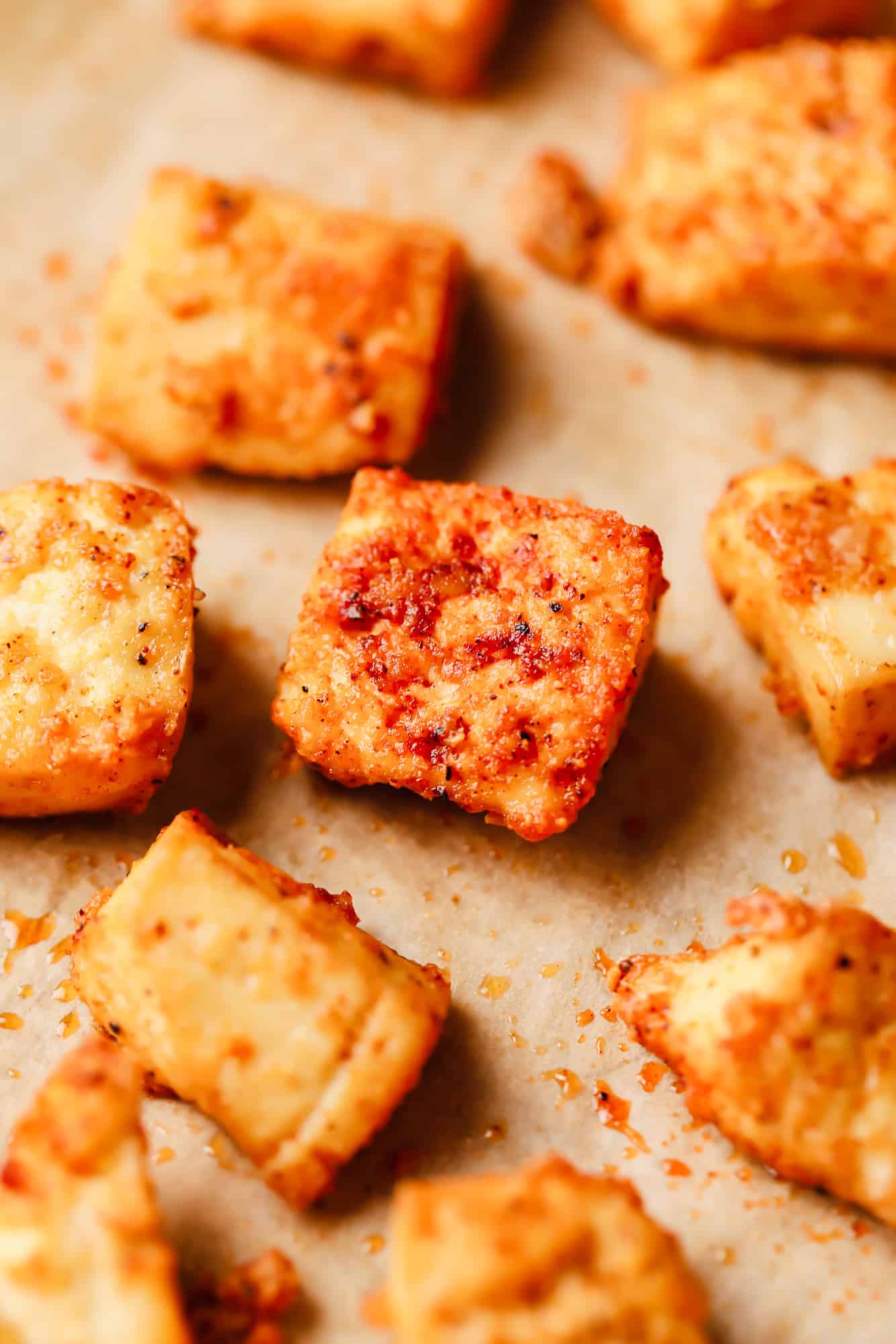 close up on pieces of baked tofu on a baking sheet.