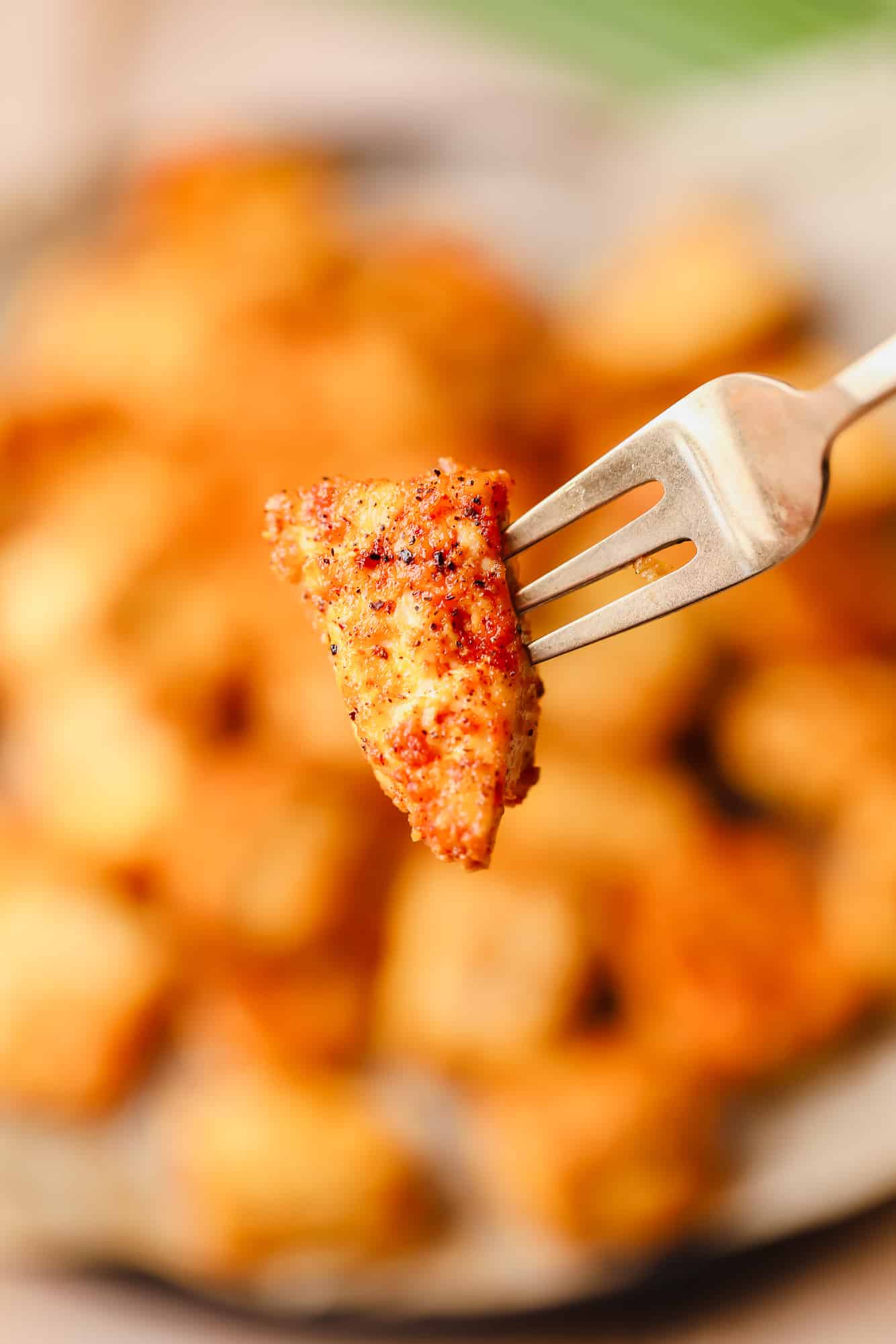 close up on a piece of crispy baked tofu on a metal fork.