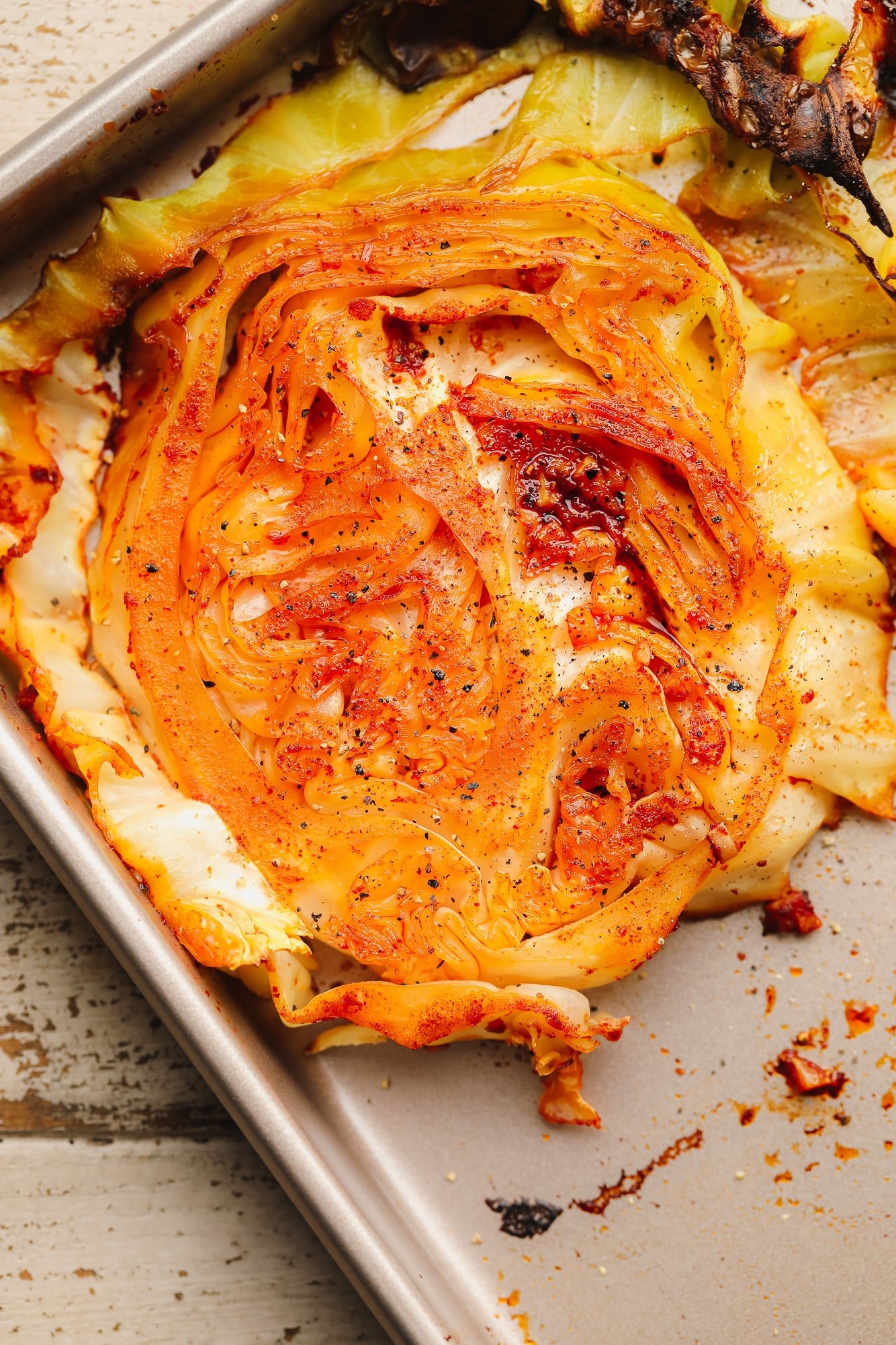 close up on a roasted cabbage steak on a metal baking sheet.