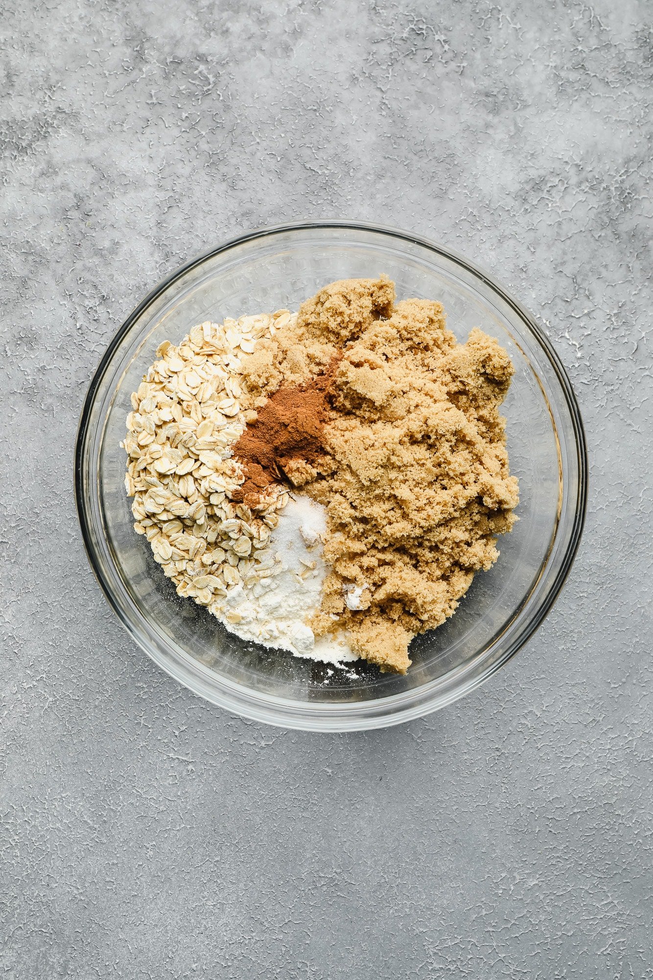 brown sugar, oats, cinnamon, and flour mixed together in a glass bowl.