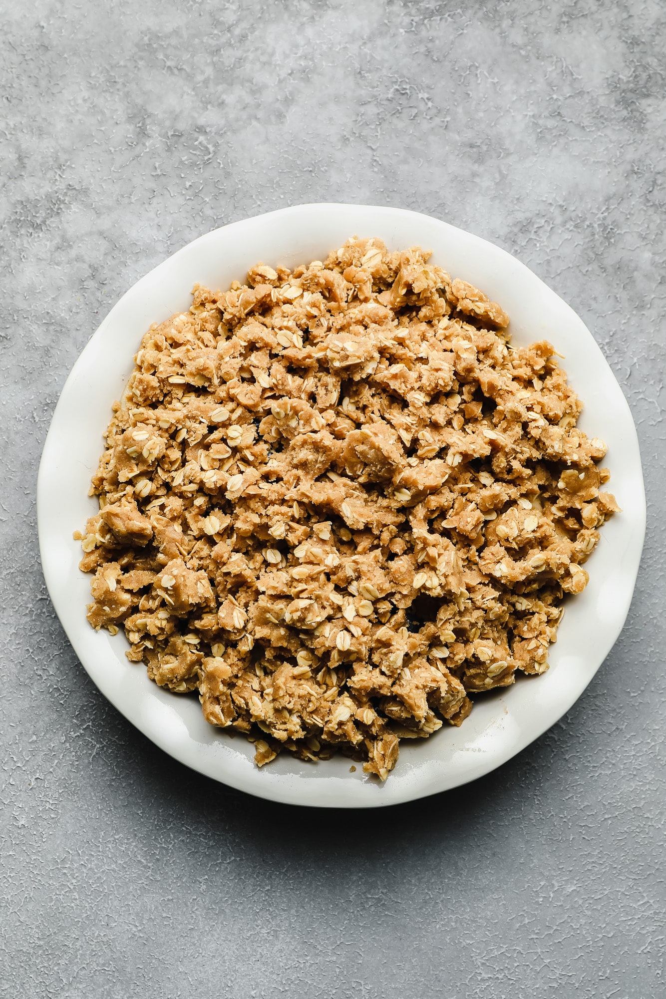 a crumbly and buttery oat crumble in a white bowl.