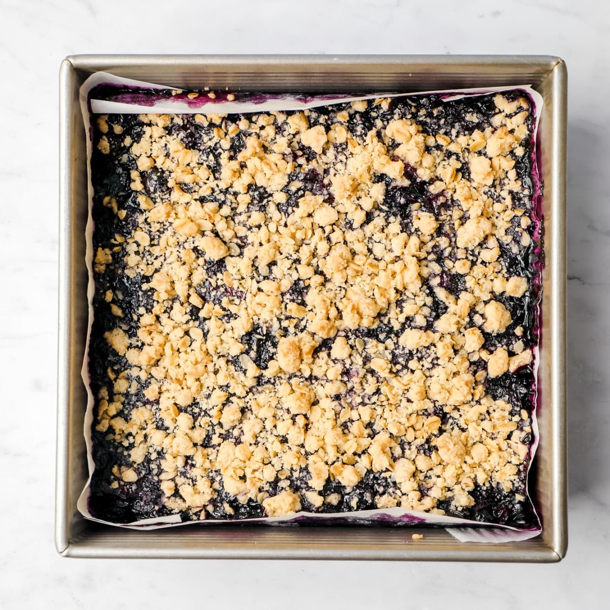 square pan with crumb topping over blueberry mixture, cooked