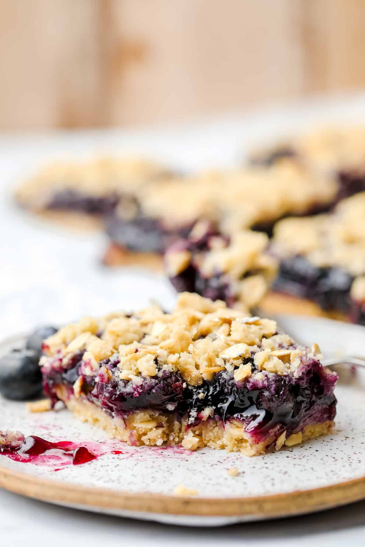 speckled plate with blueberry bar, a bite taken out showing pie middle