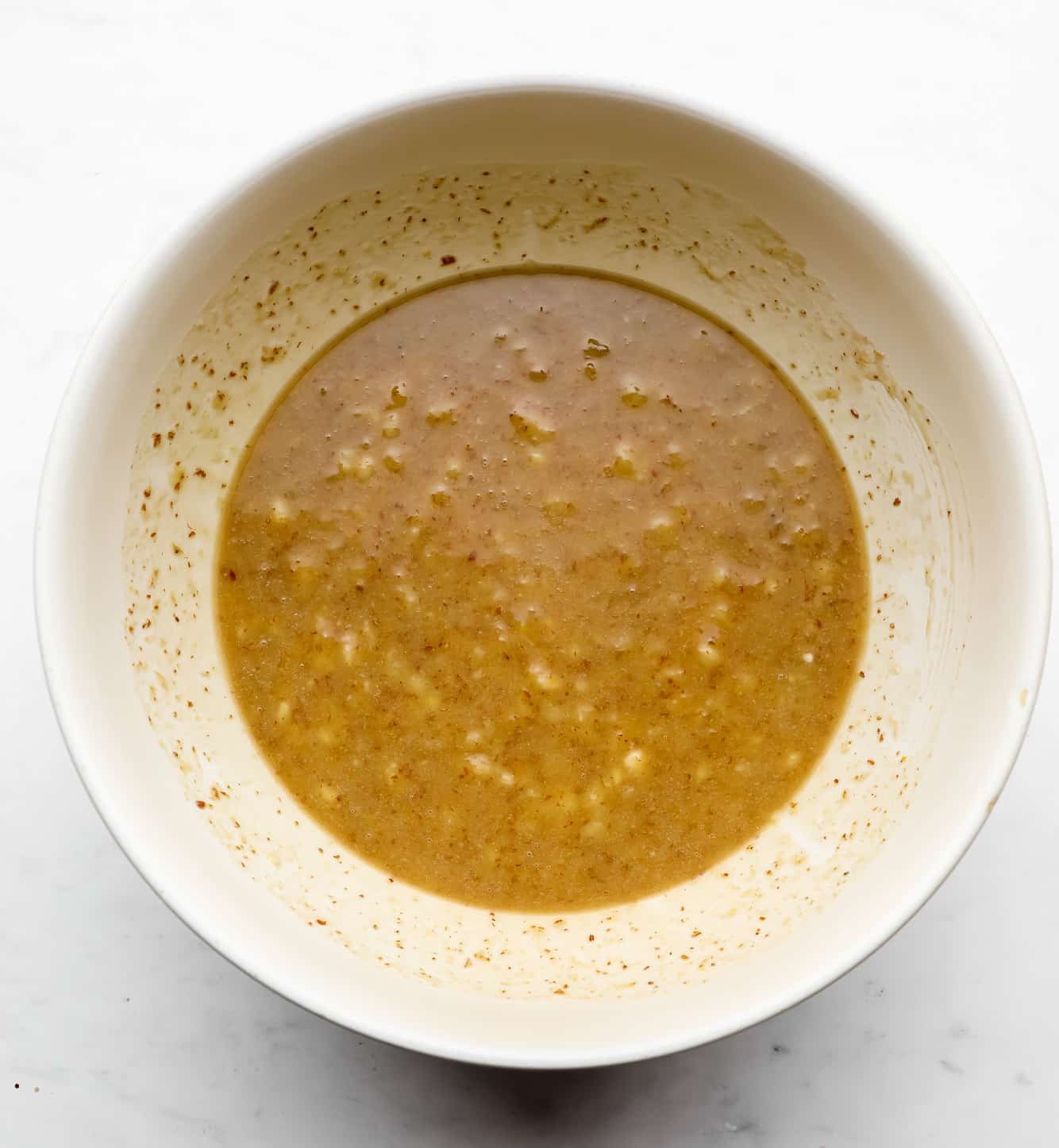 a light brown mashed banana mixture in a white bowl.