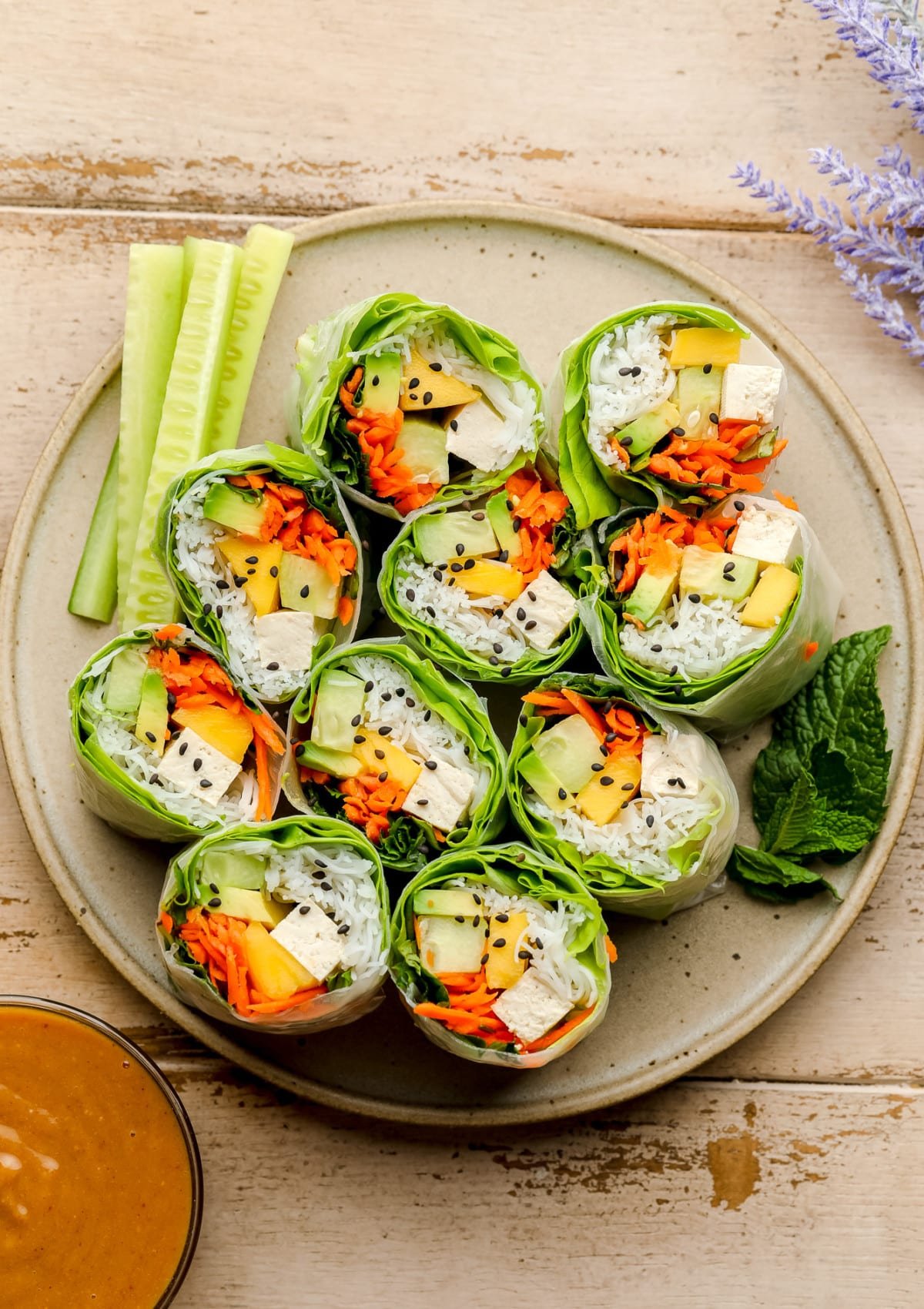 plate of salad rolls on wood background, they're cut in half showing inside