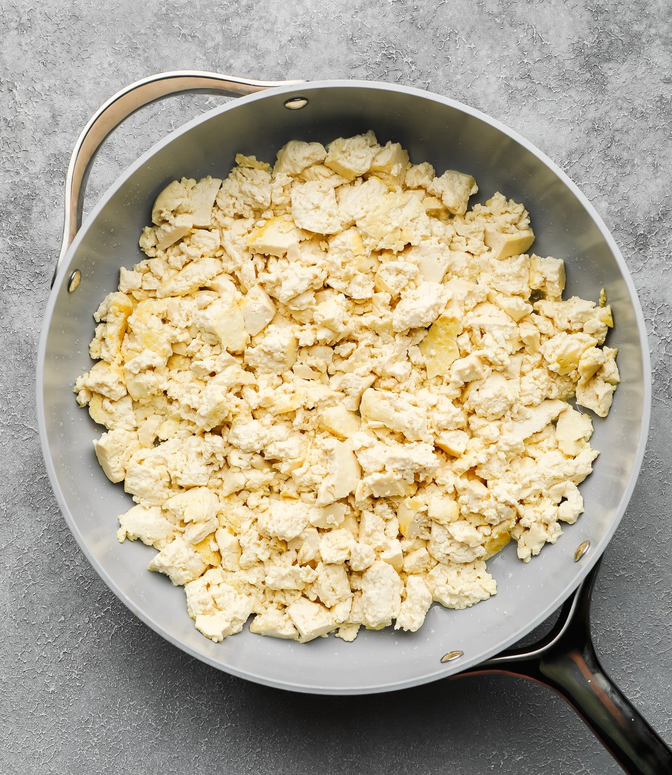 crumbled tofu frying in a large skillet.