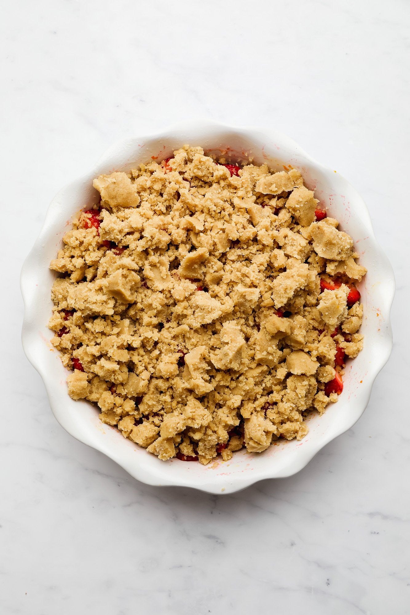 chopped strawberries with a brown crumble topping on top.