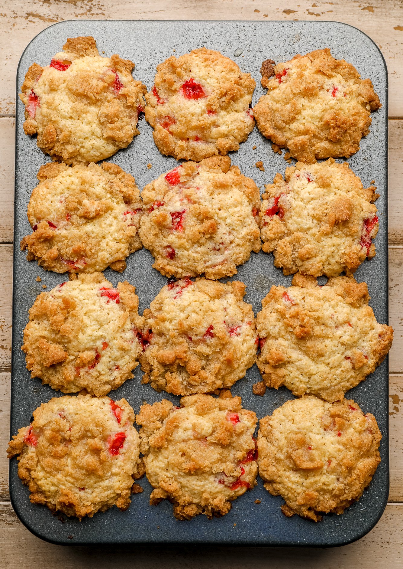 baked strawberry muffins in a muffin tin.