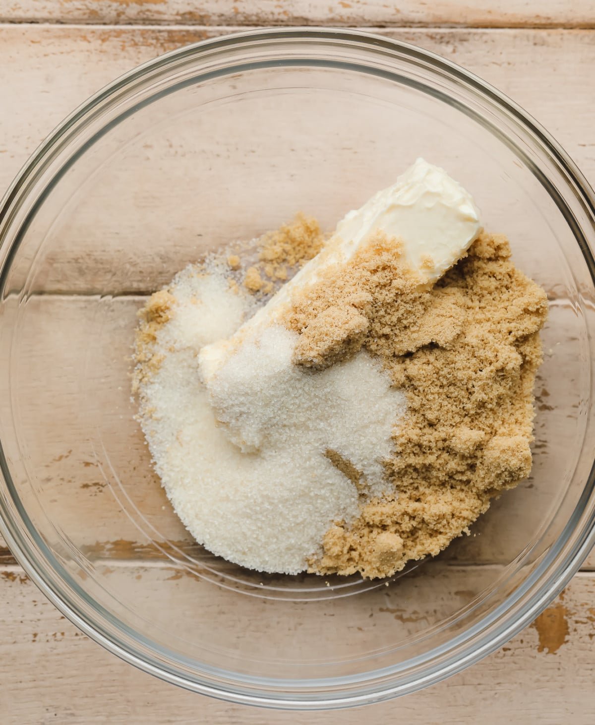 clear bowl with a stick of butter and brown and white sugar on top