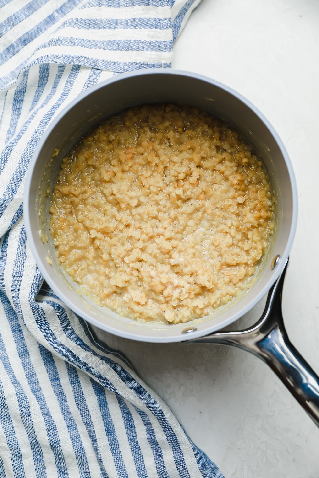 cooked red lentils in a white saucepan.