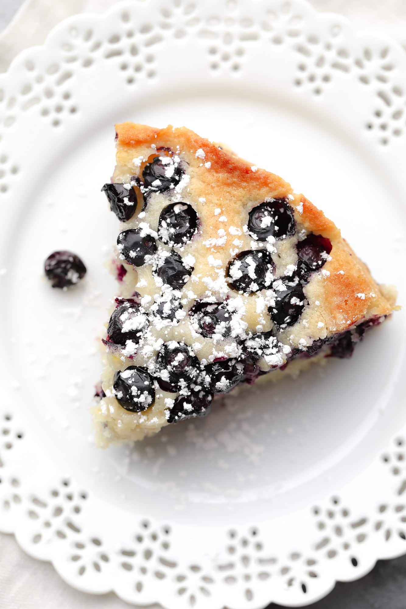 a slice of vegan blueberry cake on a white plate.