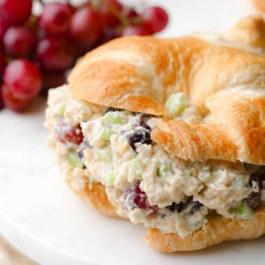 close up on vegan chicken salad in a croissant sandwich.