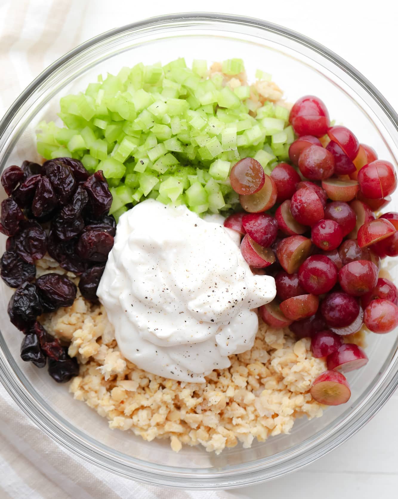 ingredients for vegan chicken salad in a large glass bowl.