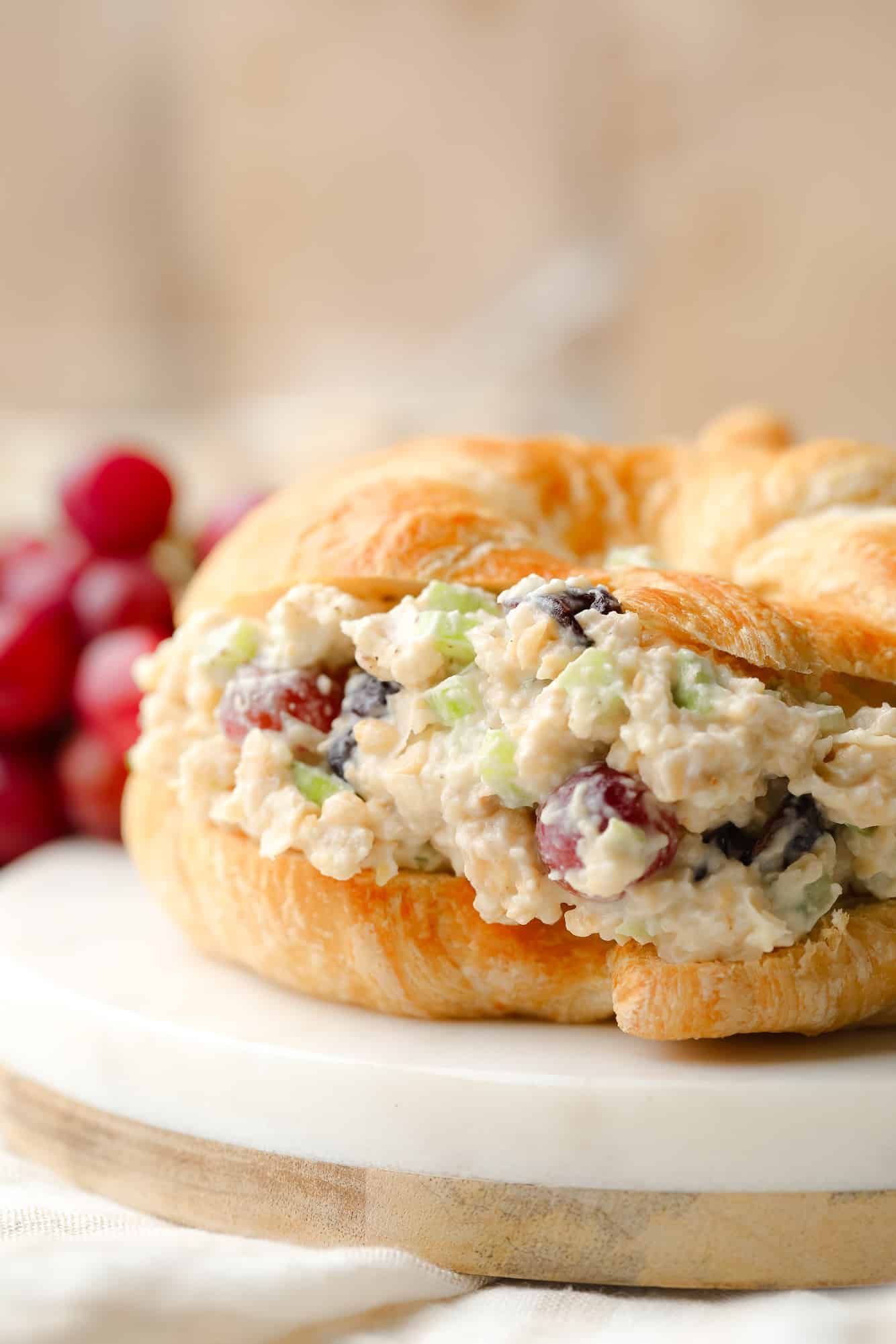 close up on vegan chicken salad in a croissant sandwich.