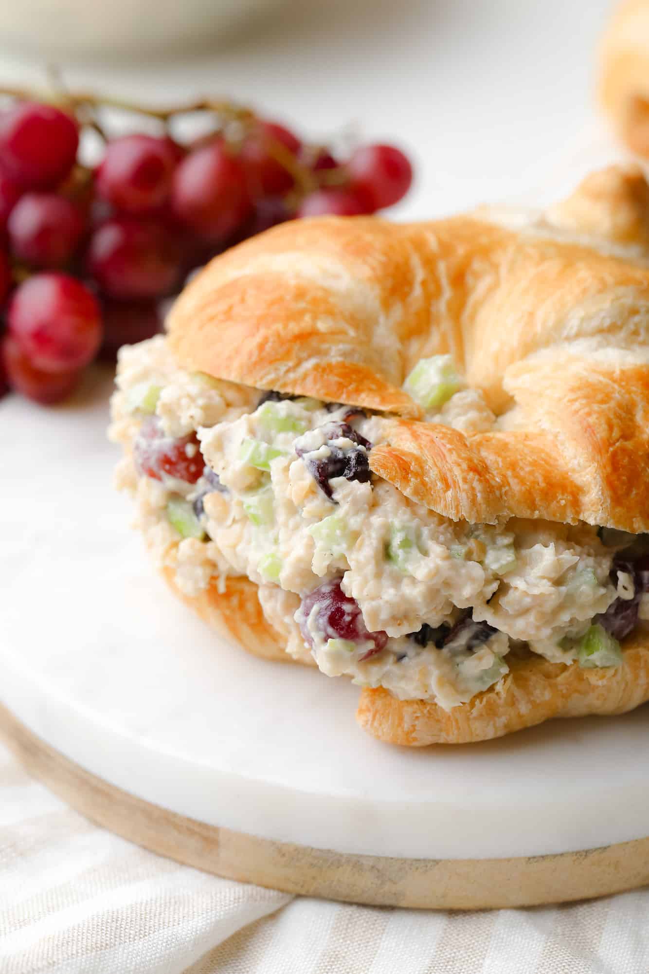 close up on vegan chicken salad in a croissant sandwich.