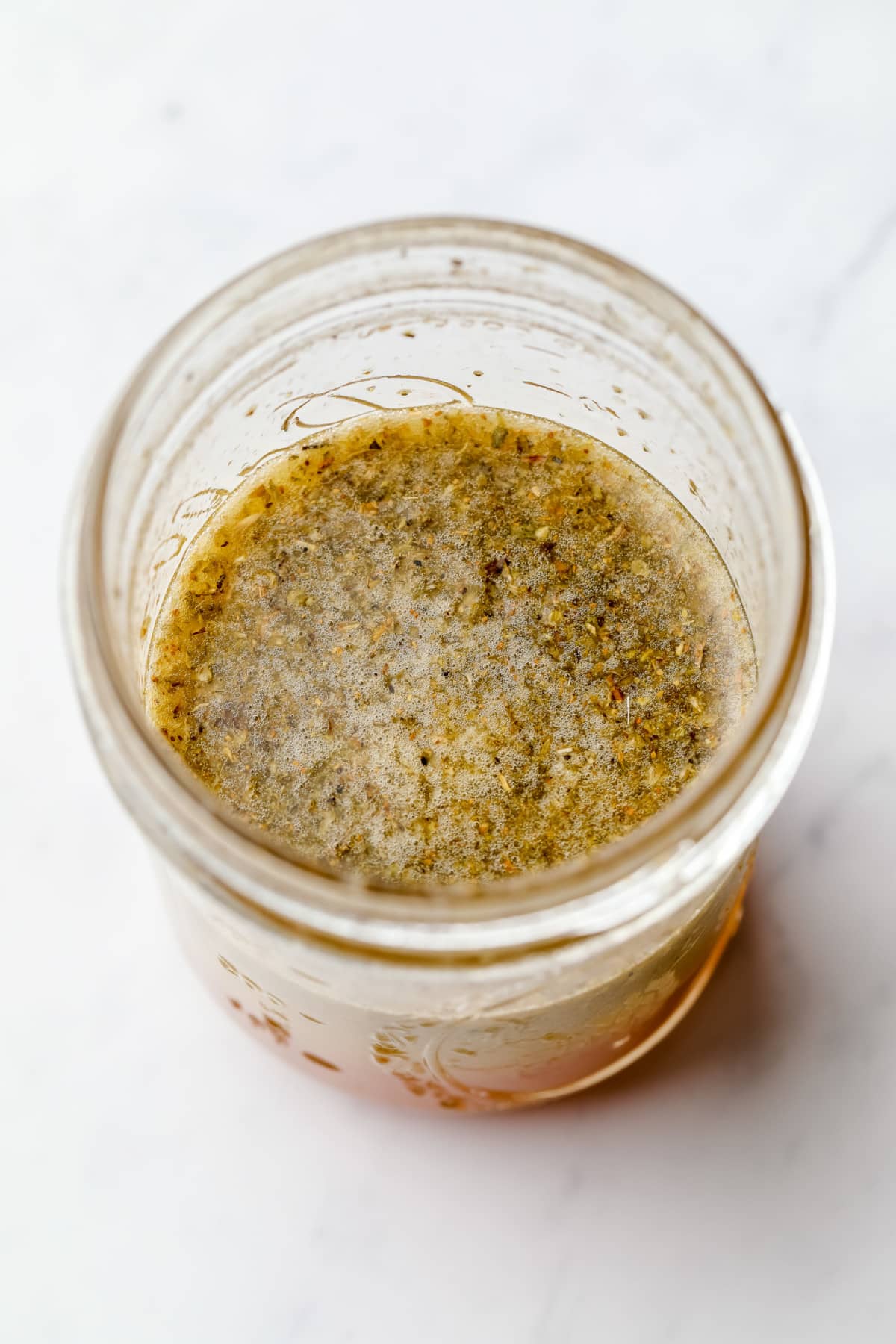 glass jar full of mixed Italian dressing