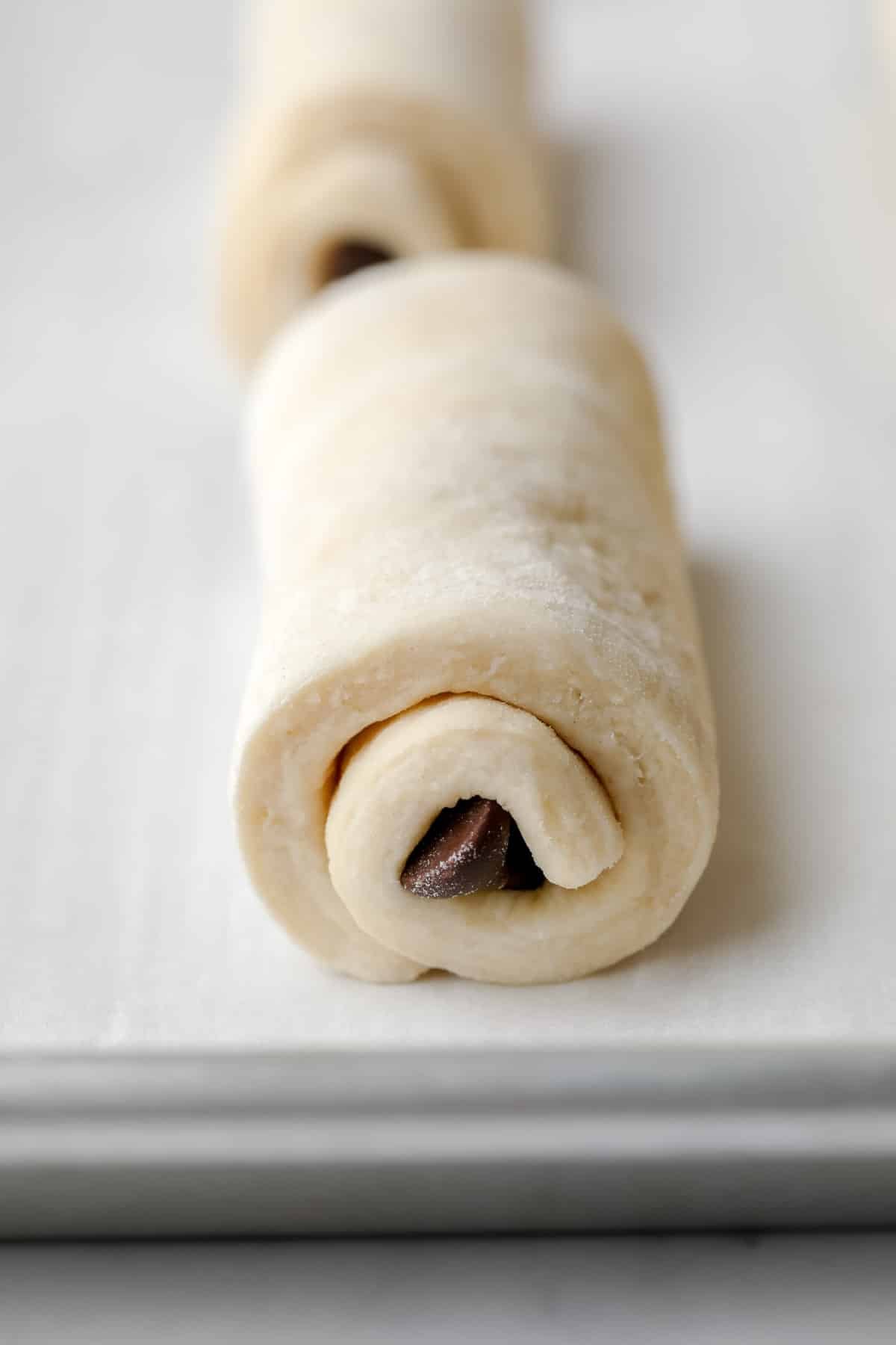 rolled chocolate filled pastry unbaked on a parchment lined pan