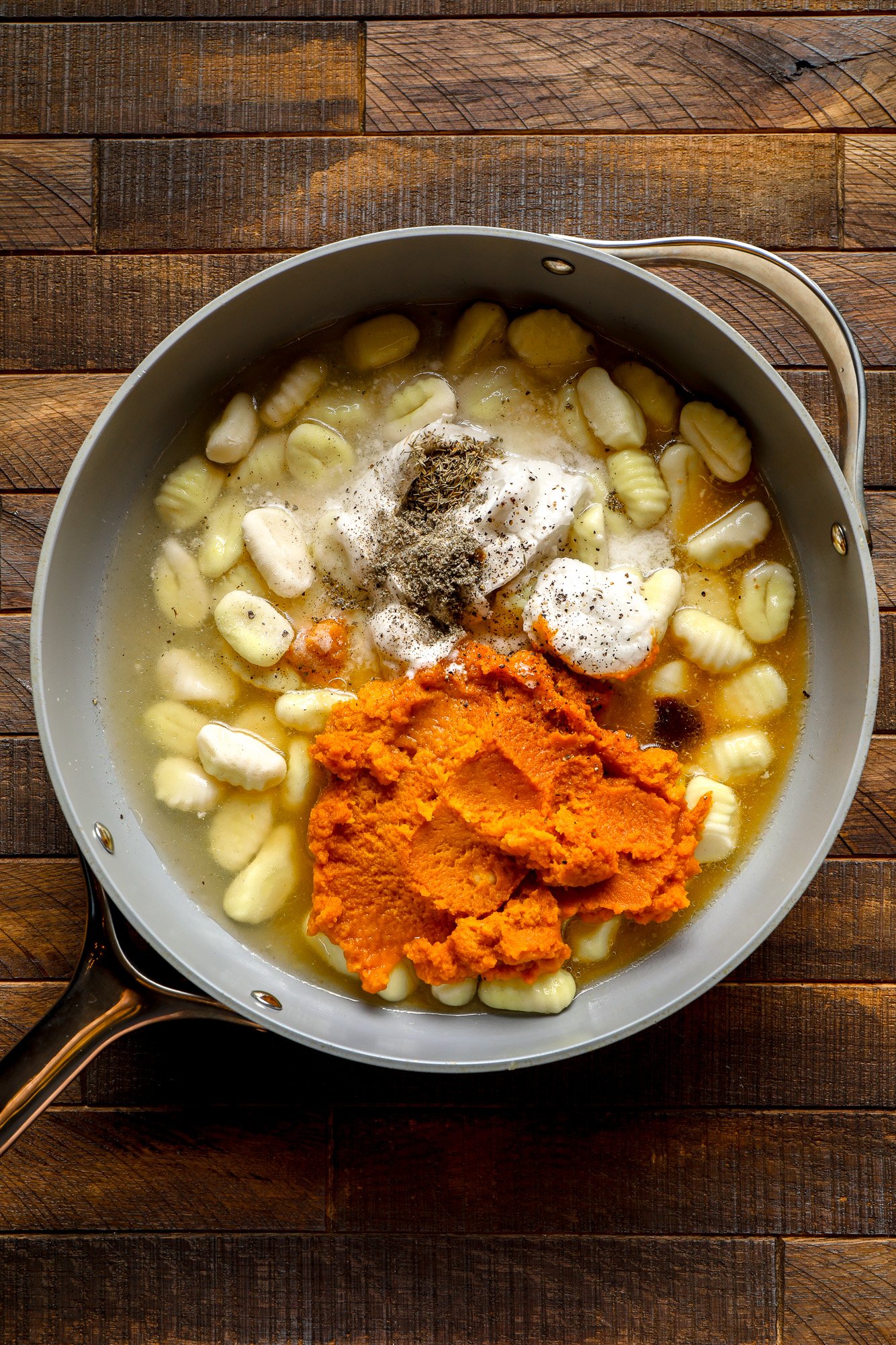 ingredients for pumpkin gnocchi in a grey pot.