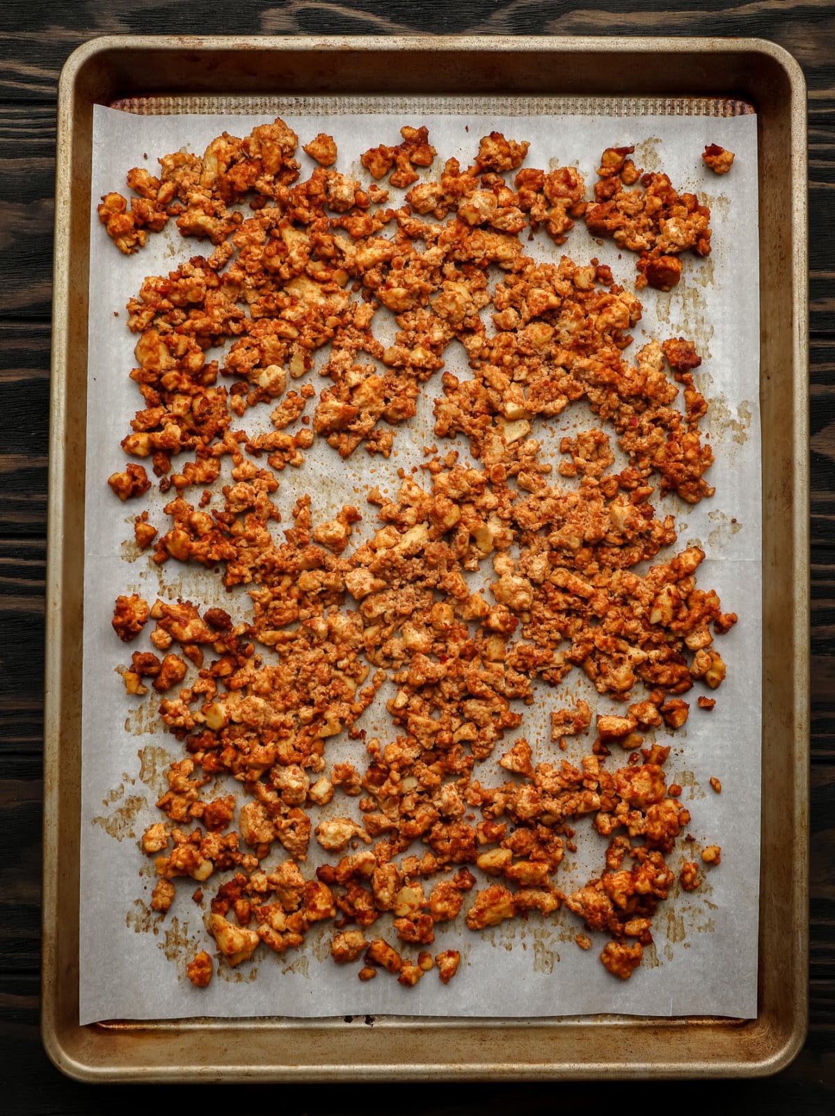 gold pan with parchment paper and cooked brown tofu crumbles