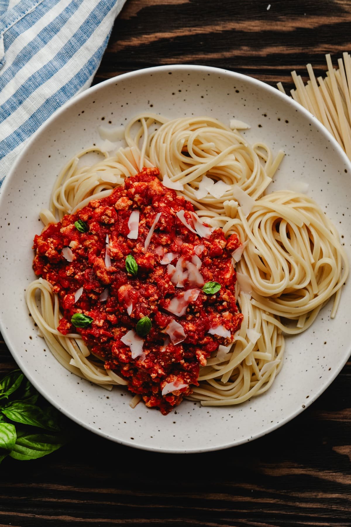speckled bowl with pasta and vegan bolognese on wood background
