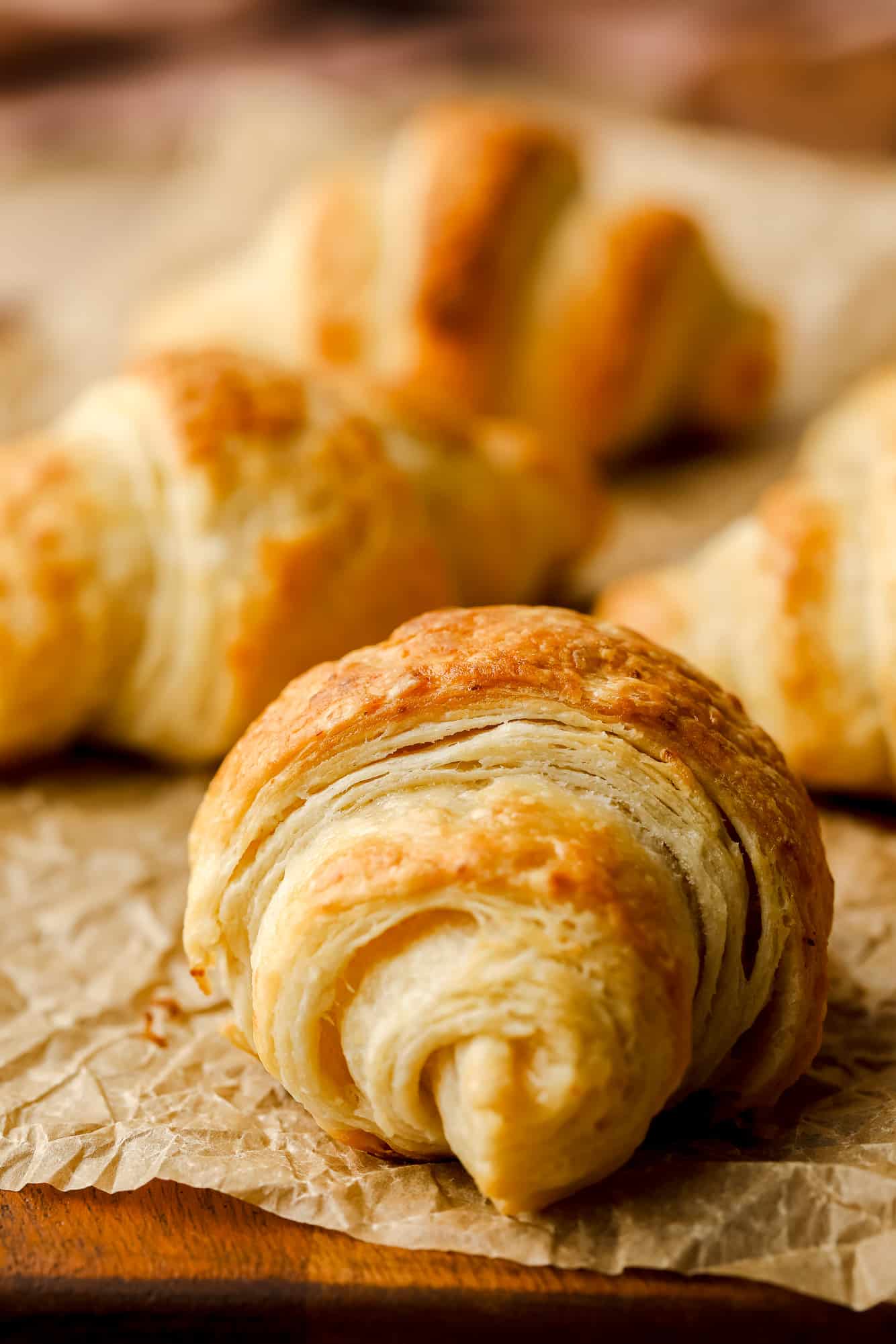 close up on a vegan croissant on a sheet of parchment paper.