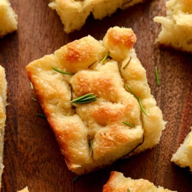 close up on a slice of vegan focaccia with rosemary on top.