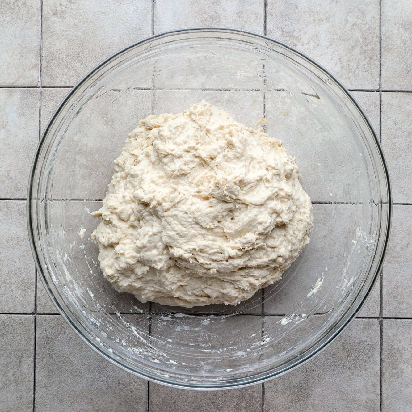 a ball of focaccia dough in a glass bowl.