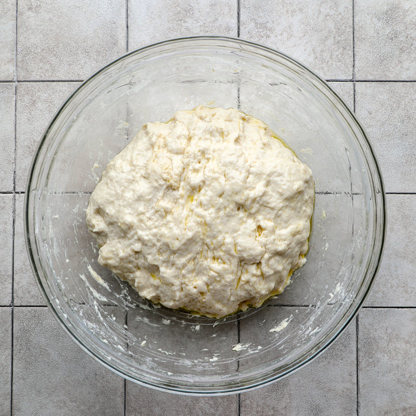 a ball of vegan focaccia dough in a glass bowl.