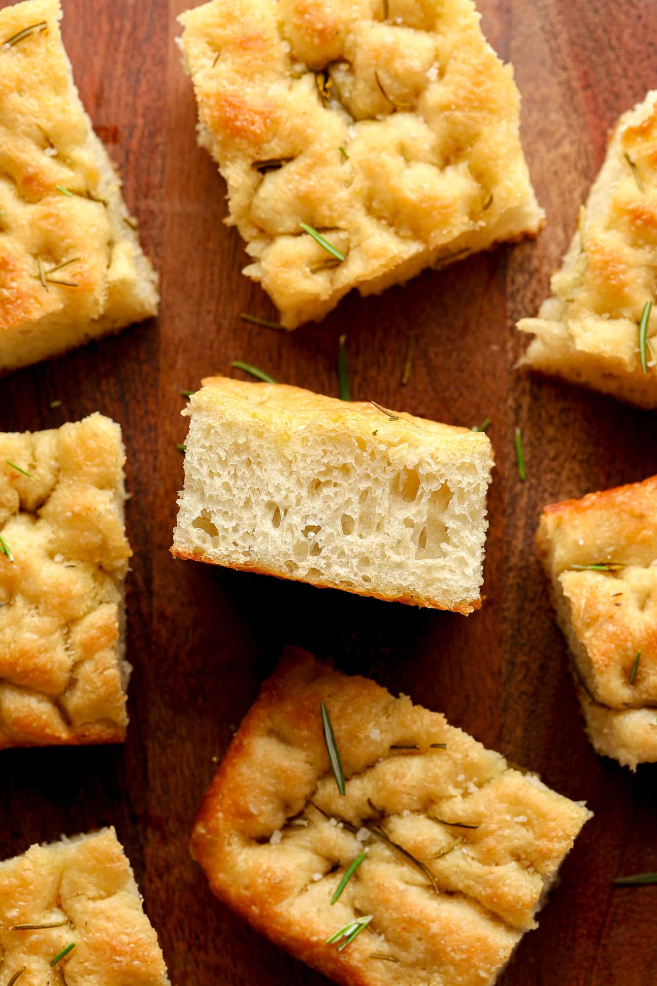 slices of baked vegan focaccia on a wood board.