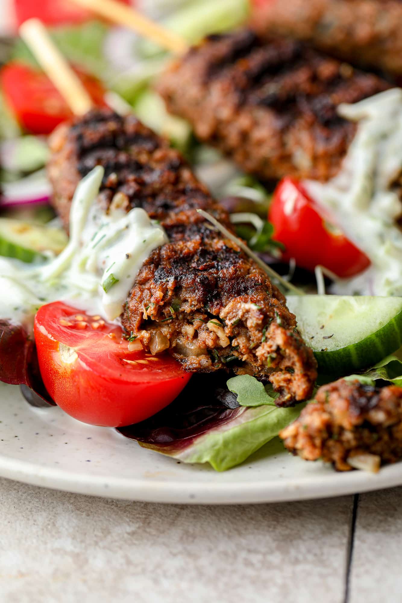 close up on a vegan kofta kebab with a bite taken out of it.