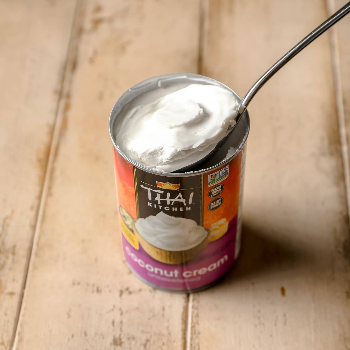 a spoon removing a scoop of coconut cream from a can.