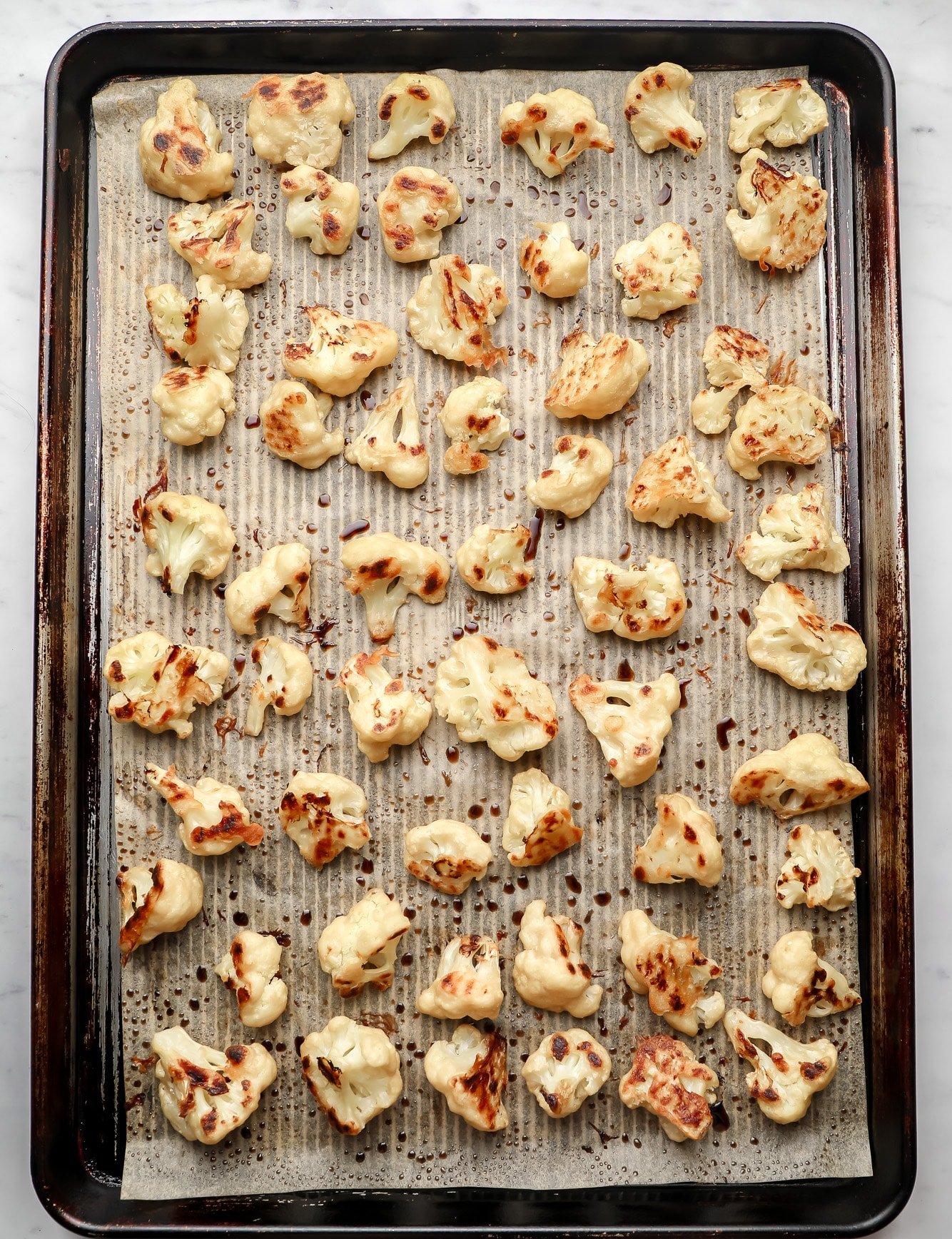 baked cauliflower in rows on a baking sheet.