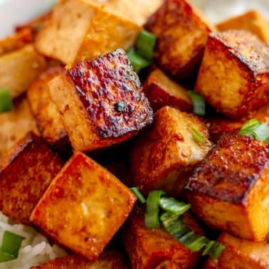 close up on a pile of cooked marinated tofu cubes.
