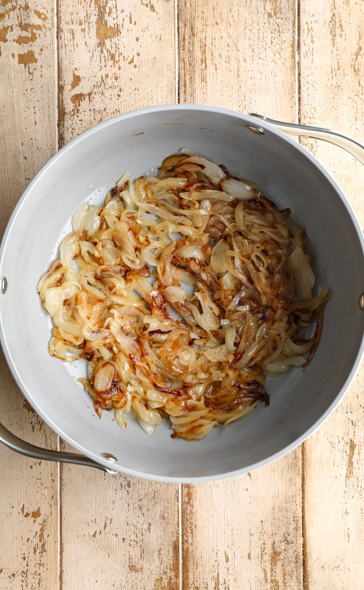 caramelized onions in the bottom of a grey pot.