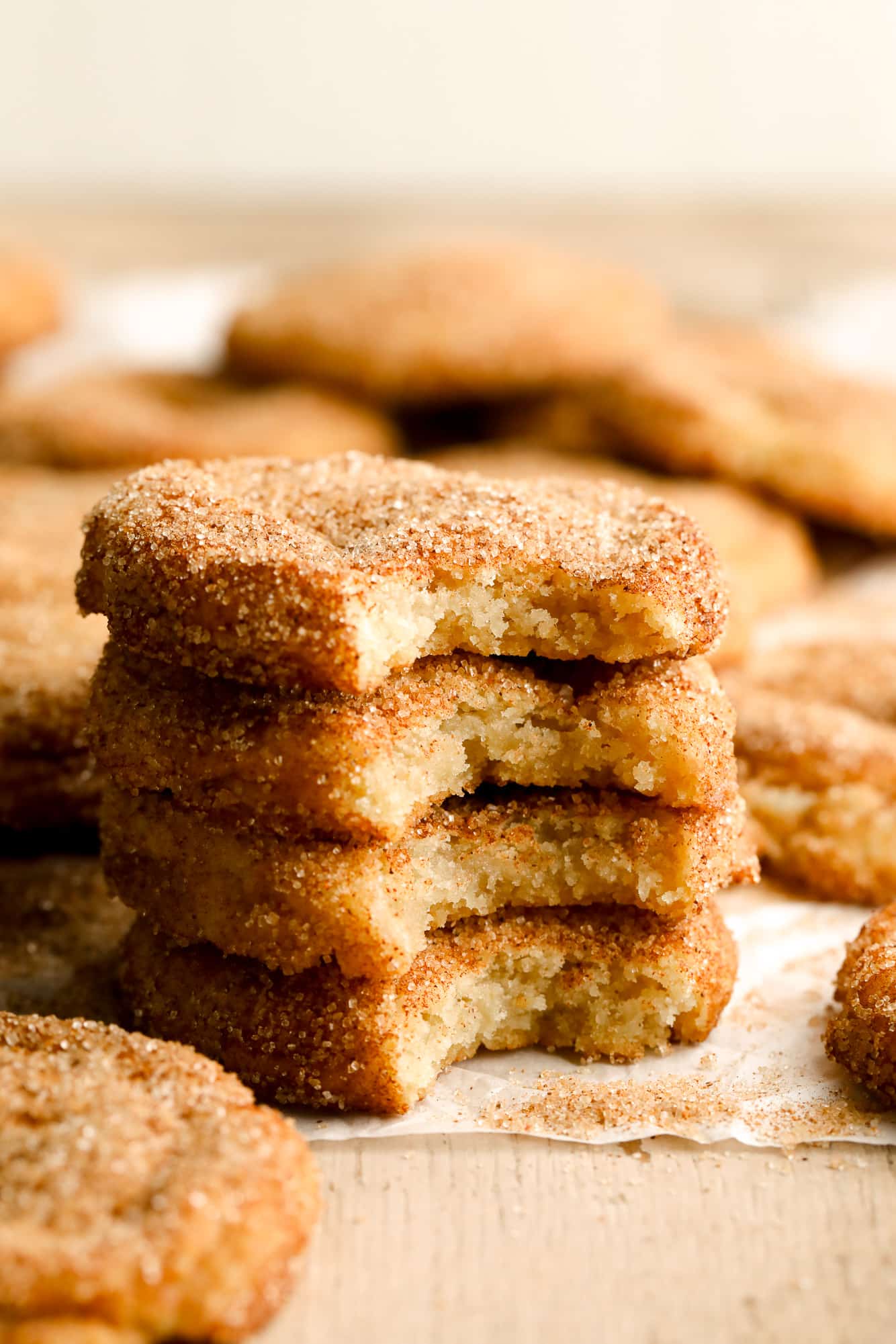 a stack of 4 vegan snickerdoodles with bites taken out of each of them.