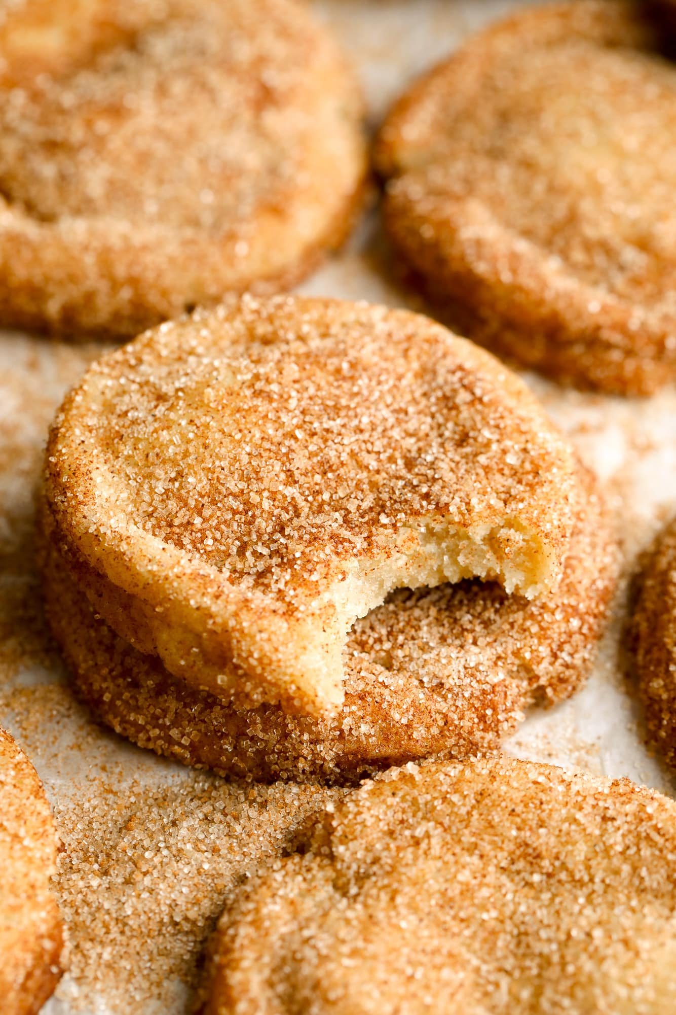 close up on a vegan snickerdoodle with a bite taken out of it.