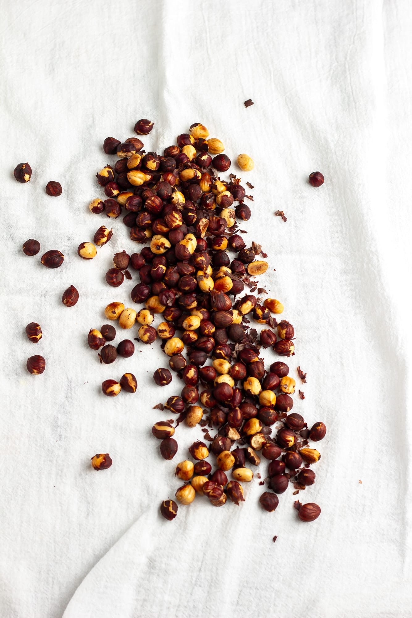 roasted hazelnuts on a white kitchen towel.