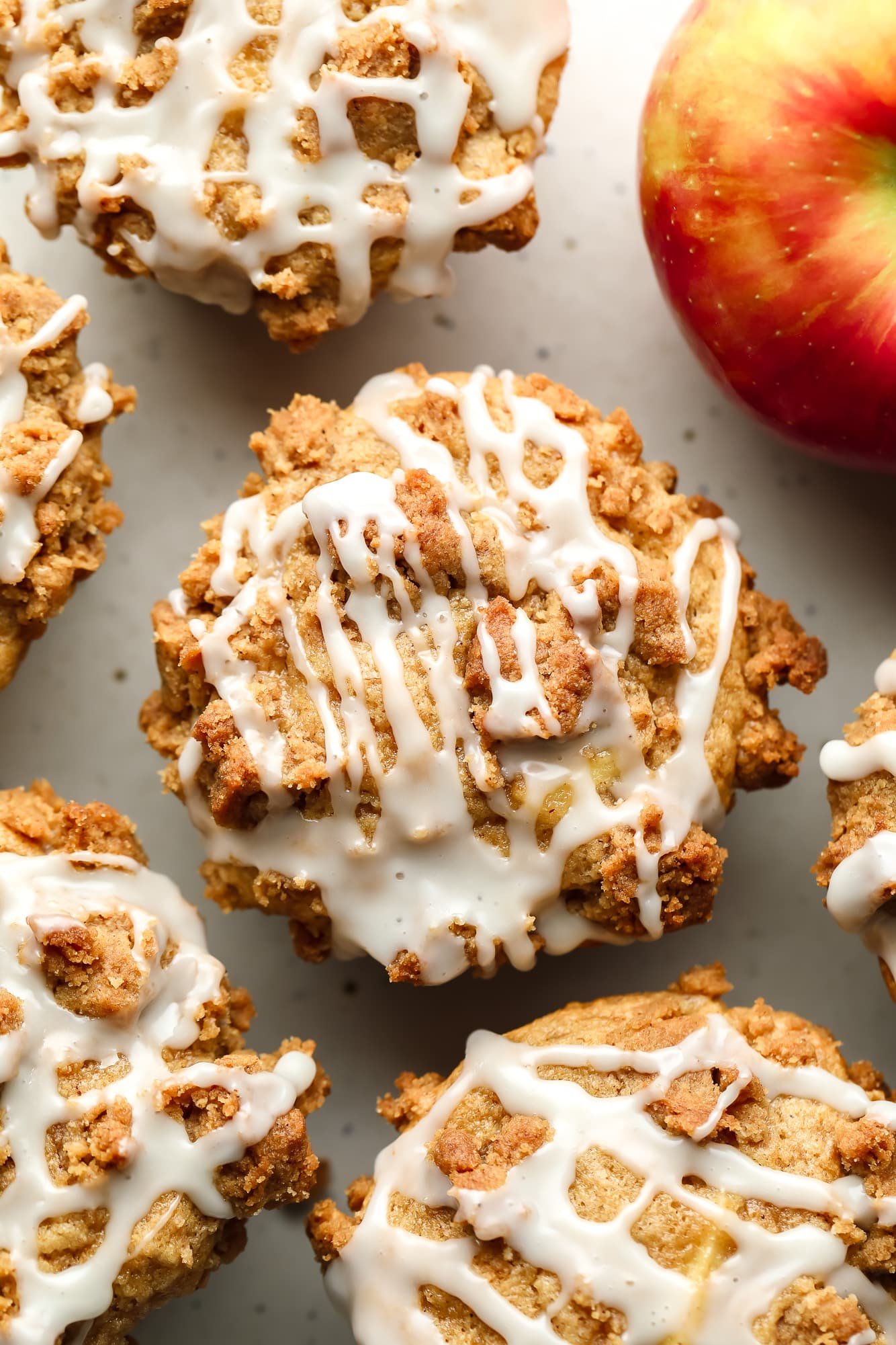 overhead view of vegan apple muffins topped with white vanilla icing.