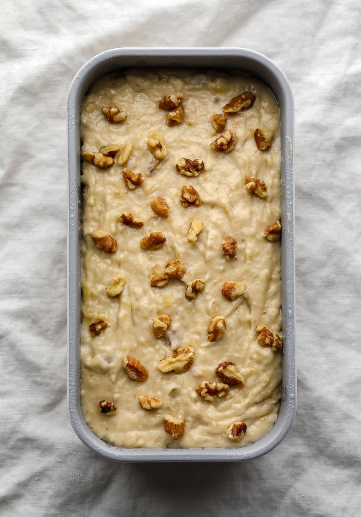 unbaked loaf of vegan banana bread with walnuts sprinkled on top