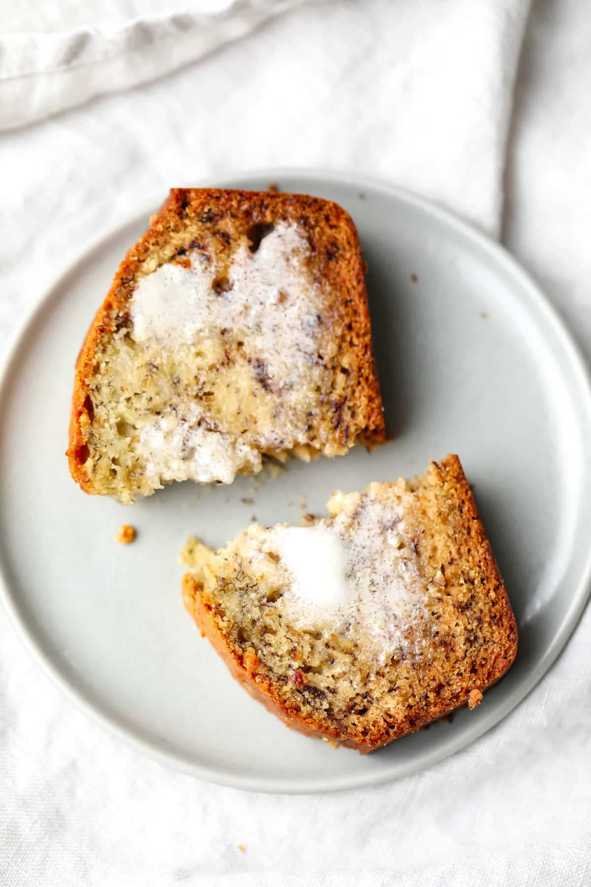 cut in half piece of banana bread with butter melted on it