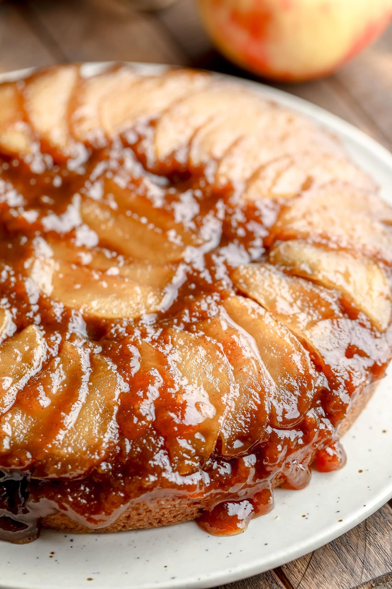 close up on a baked Apple Upside Down Cake on a white plate.