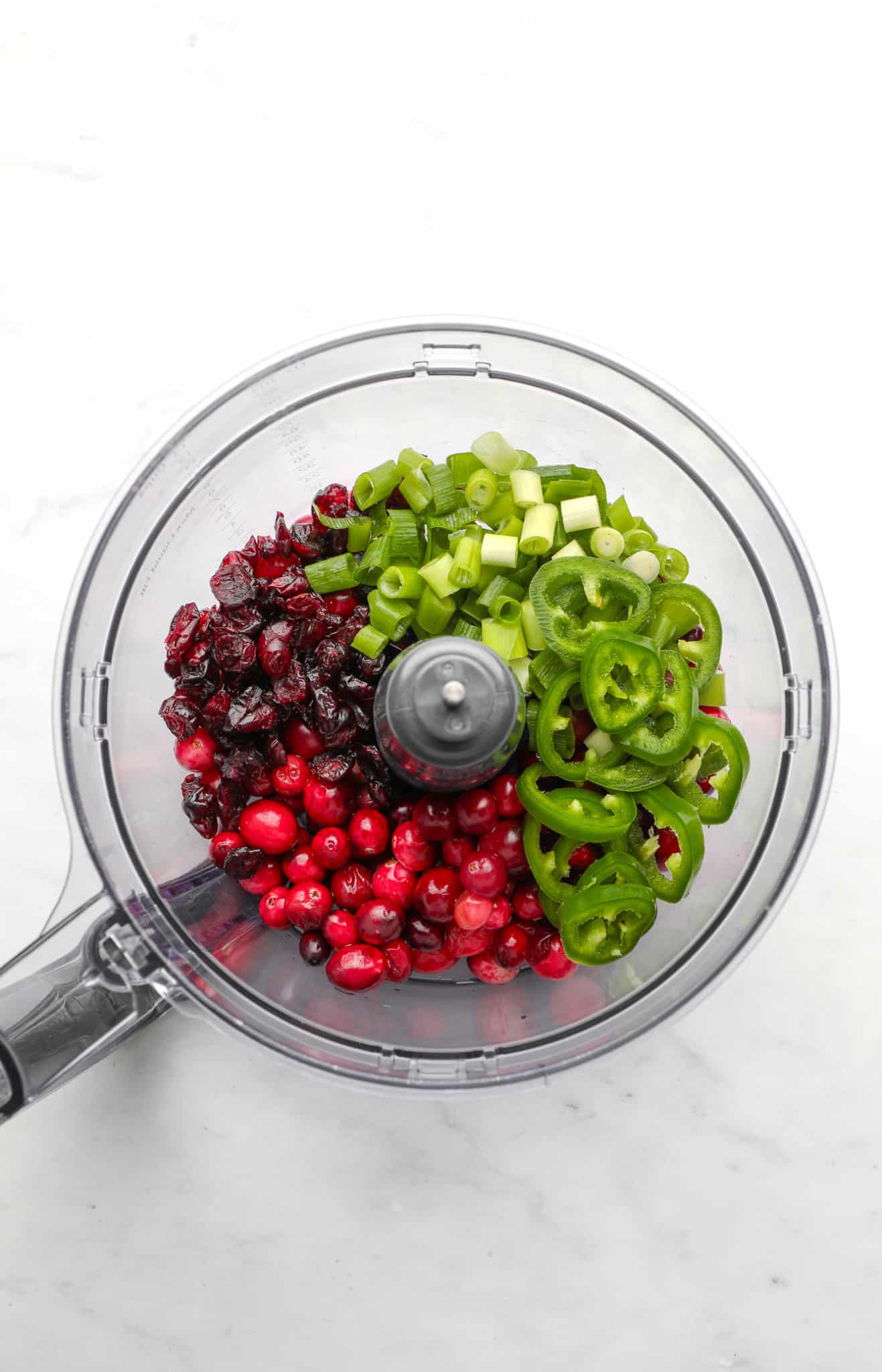ingredients for cranberry jalapeno dip in a food processor.
