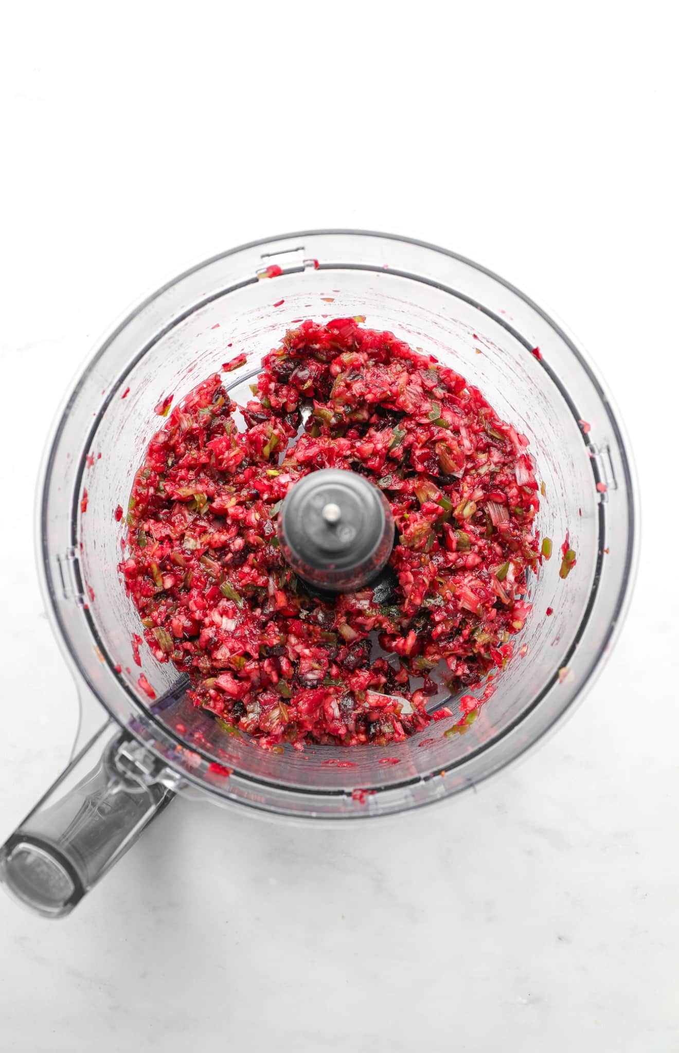 a blended mix of cranberries and jalapenos in a food processor.