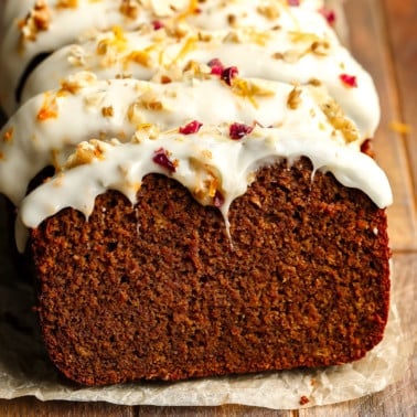 close up on a sliced Gingerbread Loaf decorated with cream cheese frosting.