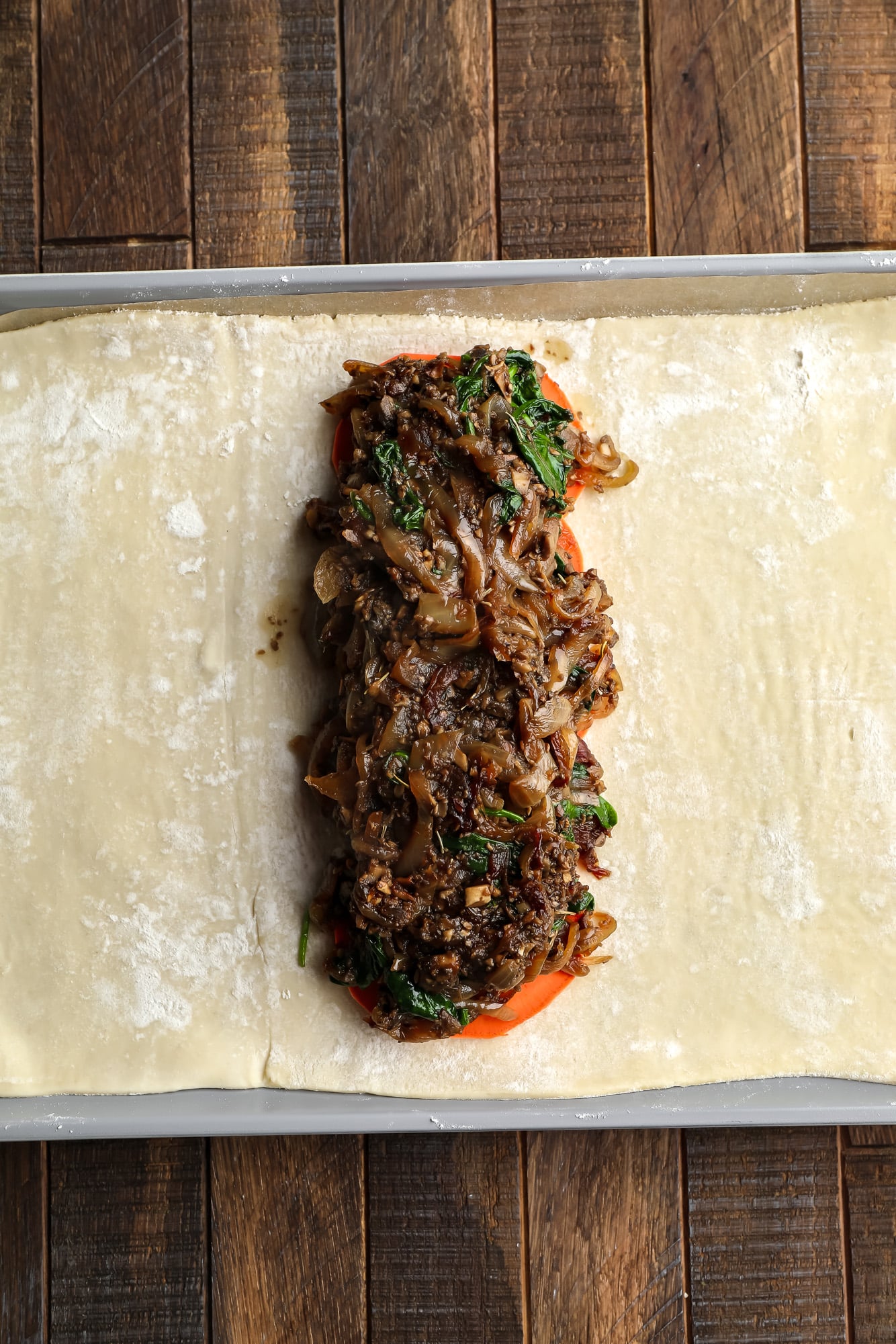 assembling the sweet potato and mushroom filling for mushroom wellington on a sheet of puff pastry.